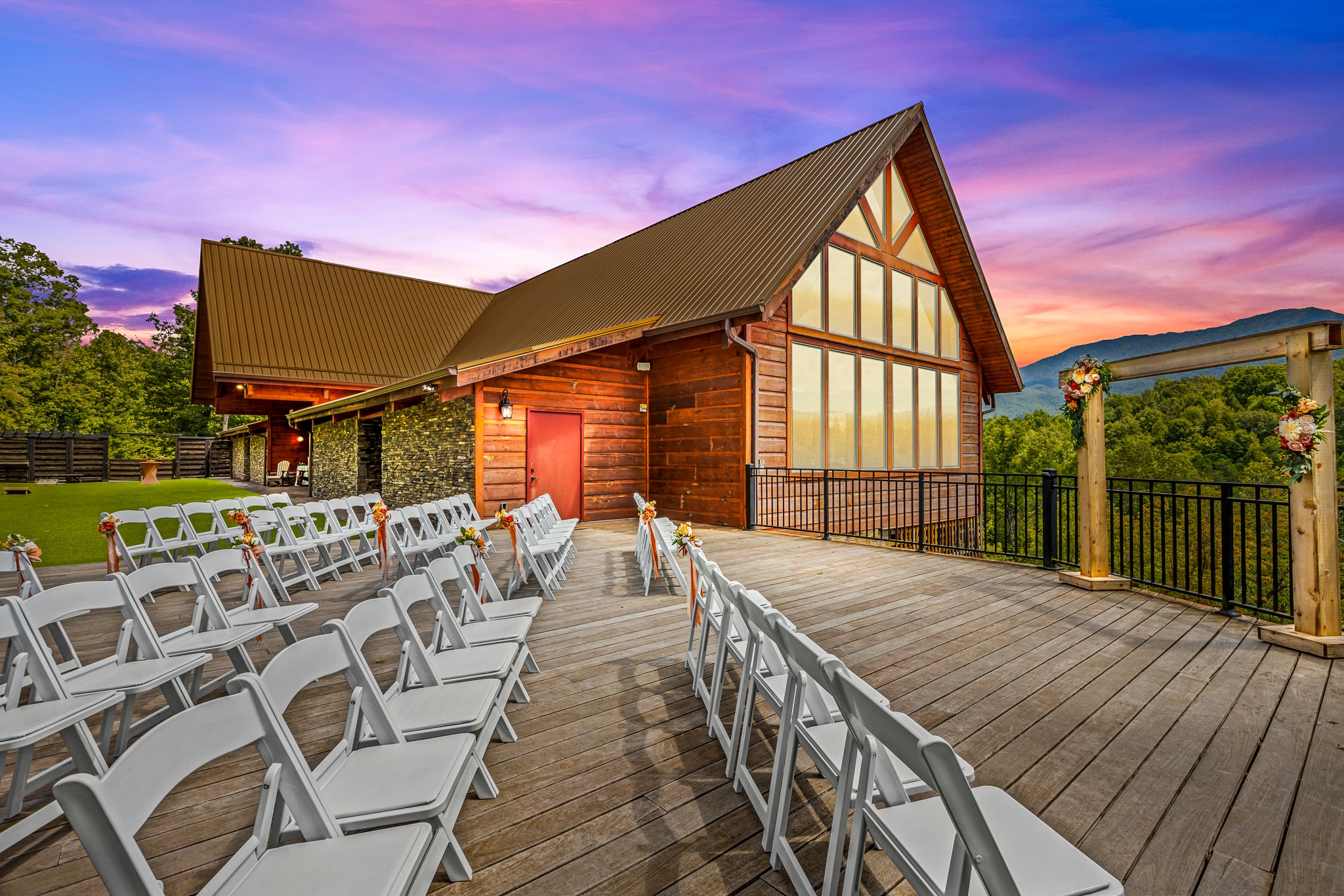 Wedding venue exterior at twilight with warm interior glow and dramatic sky